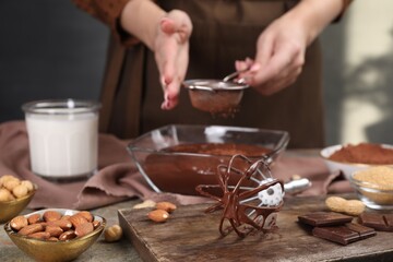 Fototapeta na wymiar Woman making chocolate cream at table, focus on whisk