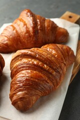 Delicious fresh croissants on grey table, closeup