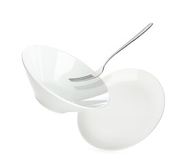 Clean dishes and fork falling on white background