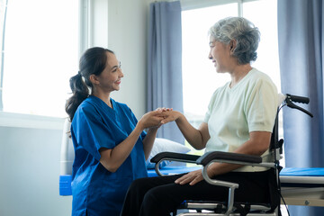 A young Asian nurse at a nursing home takes care of a senior woman. The attending physician...