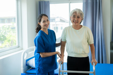 A young Asian nurse at a nursing home takes care of a senior woman. The attending physician provides physical therapy services for elderly patients to exercise for their health.