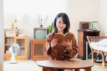 古風な雰囲気の家で読書をする若い女性