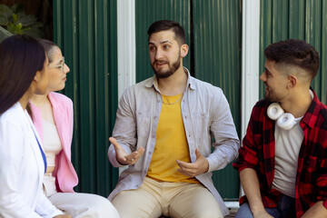 Young hipster man talks energetically to a work group.