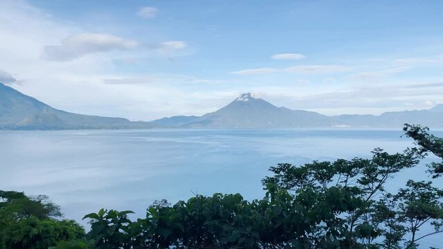 4k video footage from an elevated view panning over Lake Atitlan in Guatemala with volcanoes in the background 