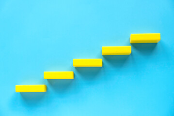 ladder of success, business grow, career path concept. Yellow wooden block in a shape of staircase.