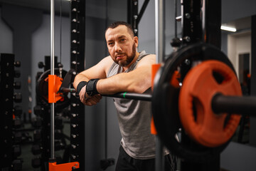 A large bearded man in the gym performs a squat exercise with a barbell. Preparation of a weightlifter for competitions Natural weight gain without the use of steroids.