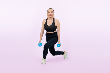 Full body length shot active and sporty senior woman lifting dumbbell during weight training workout on isolated background. Healthy active physique and body care lifestyle for pensioner. Clout