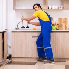 Young male contractor repairing tap at home