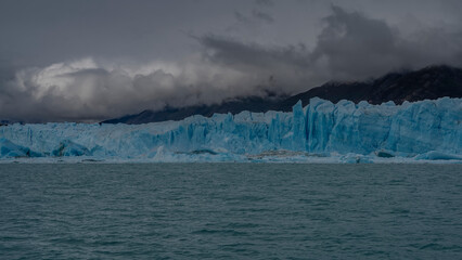 The impressive Perito Moreno glacier in a turquoise glacial lake. A wall of cracked ice against the...