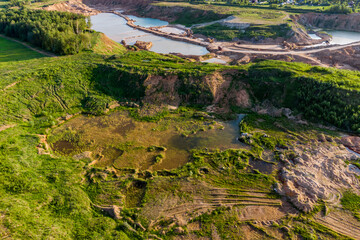 Aerial view of a sand quarry with overgrown slopes