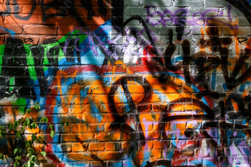 Illegal graffiti and writing on a brick wall - obrazy, fototapety, plakaty