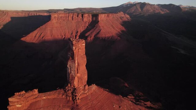 Gold sunset shadow aerial orbits Castleton Tower rock spire near Moab