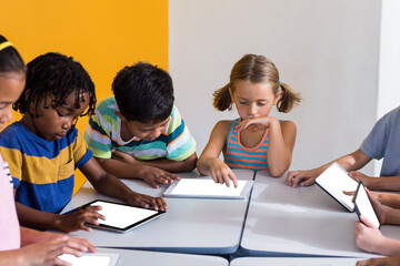 Digital png photo of diverse schoolchildren using tablets with copy space on transparent background