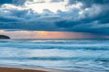Fototapeta na wymiar Sunrise seascape with low clouds and waves