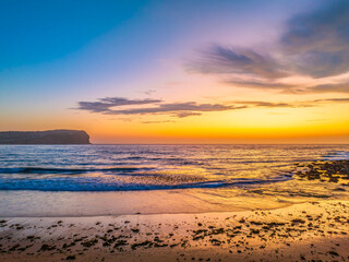 Fototapeta na wymiar Sunrise at the seashore with colour in the clouds