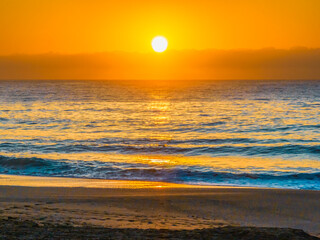 Pretty blue sunrise at the beach with calm seas