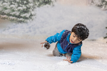 mexican little boy playing with artificial snow on with christmas background