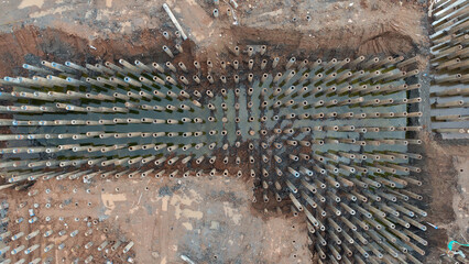 View from above of piles that have been driven into a large construction area. These piles are round and are a type of foundation for high rise buildings. About piling work.