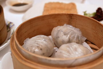 Close up vof steamed prawn dumplings with steam on table