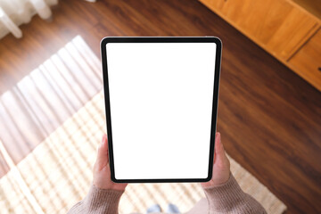 Top view mockup image of a woman holding digital tablet with blank desktop screen at home
