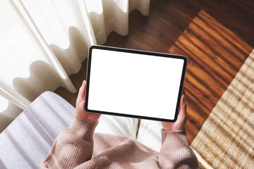 Top view mockup image of a woman holding digital tablet with blank desktop screen at home
