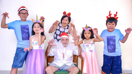 Joyful expression of grandpa and grandma having Christmas photo session with their grandchildren