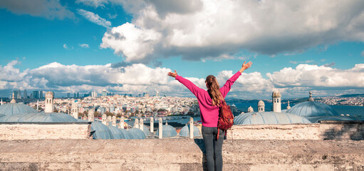 Panoramic view of Istanbul city, Woman with arms raised up enjoys the view- Turkey, Galata Tower in...