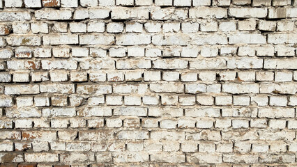 White wall of old dilapidated brick. The background of shabby brickwork.