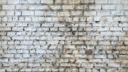 An old dilapidated brick wall made of white cypress. The background is made of shabby brickwork....