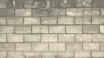 The wall is made of smooth gray large textured brick. Beautiful brickwork background.