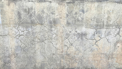 An old dirty battered concrete wall with cracks. The dilapidated wall of the building, tarnished by...