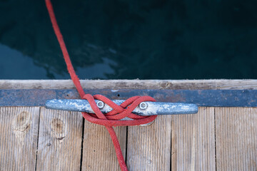 rope and cleat on wooden pier.