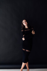 Fototapeta na wymiar Brunette in black clothes posing on black background