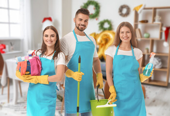 Team of janitors with cleaning supplies on white background