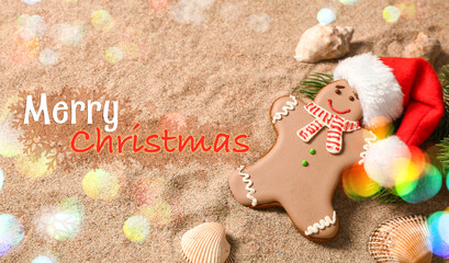 Sweet gingerbread cookie and Santa hat on beach sand. Christmas vacation