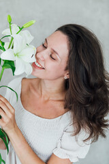 Portrait of a beautiful brunette woman with lily flowers