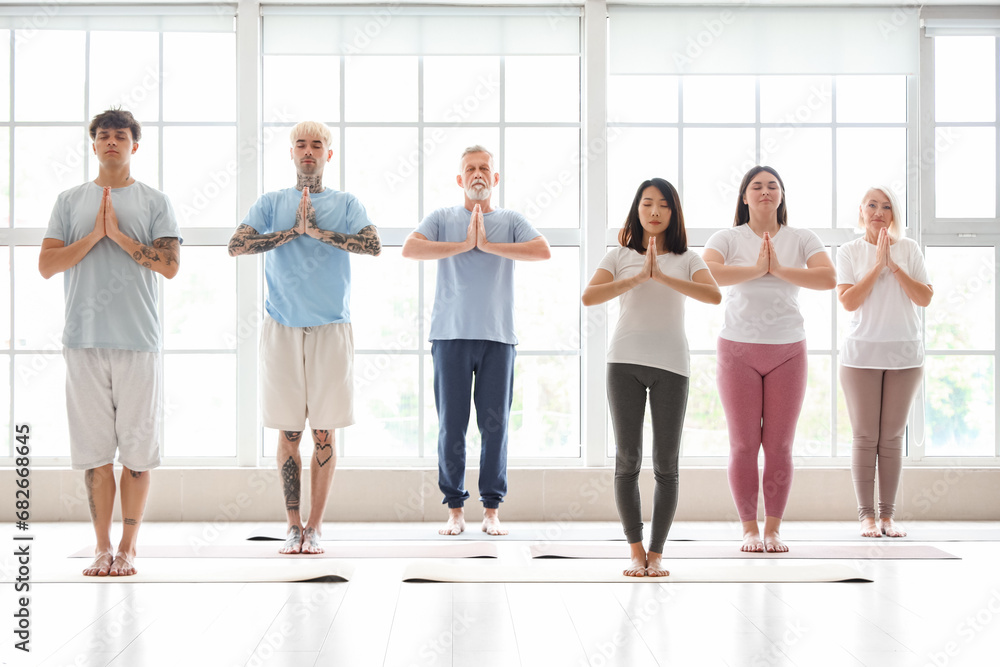 Sticker group of sporty people meditating in gym