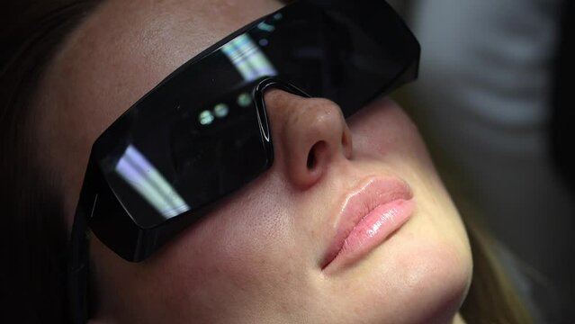 Dental Whitening process in patient mouth. Teeth whitening with UF Lamp, Led Lamp and gel. Dental Extreme Close up Macro Video. Concept of professional dental hygiene. 4k 120 fps slow motion footage