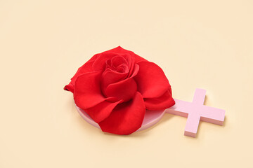 Female gender symbol with beautiful red rose on beige background
