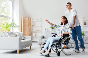 Young man and his wife in wheelchair at home