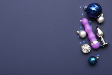 Sex toys with Christmas balls and confetti on blue background