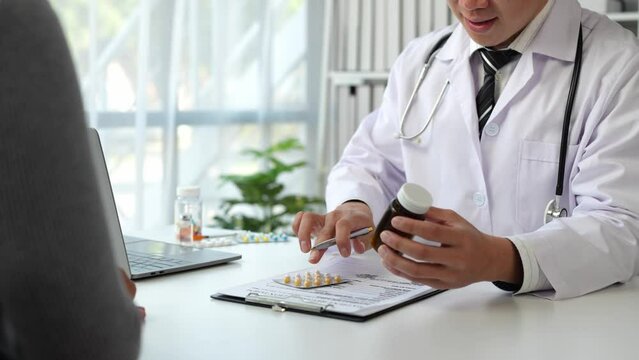 Doctor, pharmacist pointing at pill bottle, giving advice, recommending how to take medicine to female patient, explaining prescription to business woman Medical and health care system.