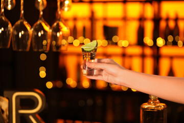 Woman with tequila shot in bar, closeup