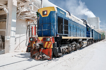 Shunting diesel locomotive moves cars at silica factory