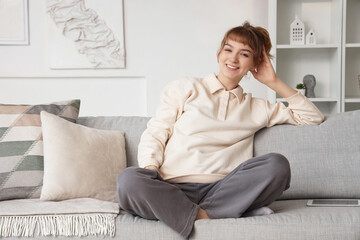 Obraz premium Young woman with tablet computer relaxing on sofa at home