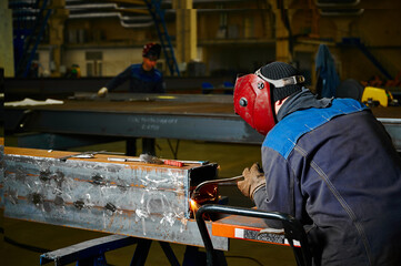 Gas welder cuts a metal beam with a gas cutter