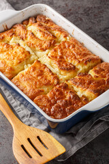 Butter Swim Biscuits are buttermilk biscuits that are baked drenched in butter for a biscuit that has a crispy crust with a soft and fluffy inside closeup on the table. Vertical