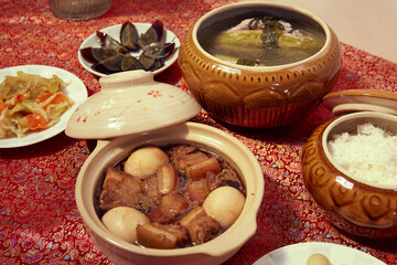 Family dinning table of Tet holiday or Lunar New Year with traditional foods: pork belly and eggs...