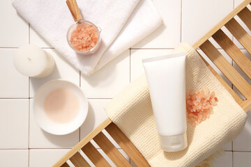 Unlabeled beauty tube on a pastel towel in a wooden frame, with a glass of water and pink salt....