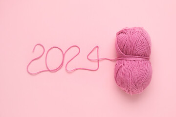 Figure 2024 made of knitting yarn on pink background